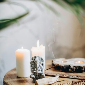 Serene still life featuring Ganesha statue, candles, and incense.